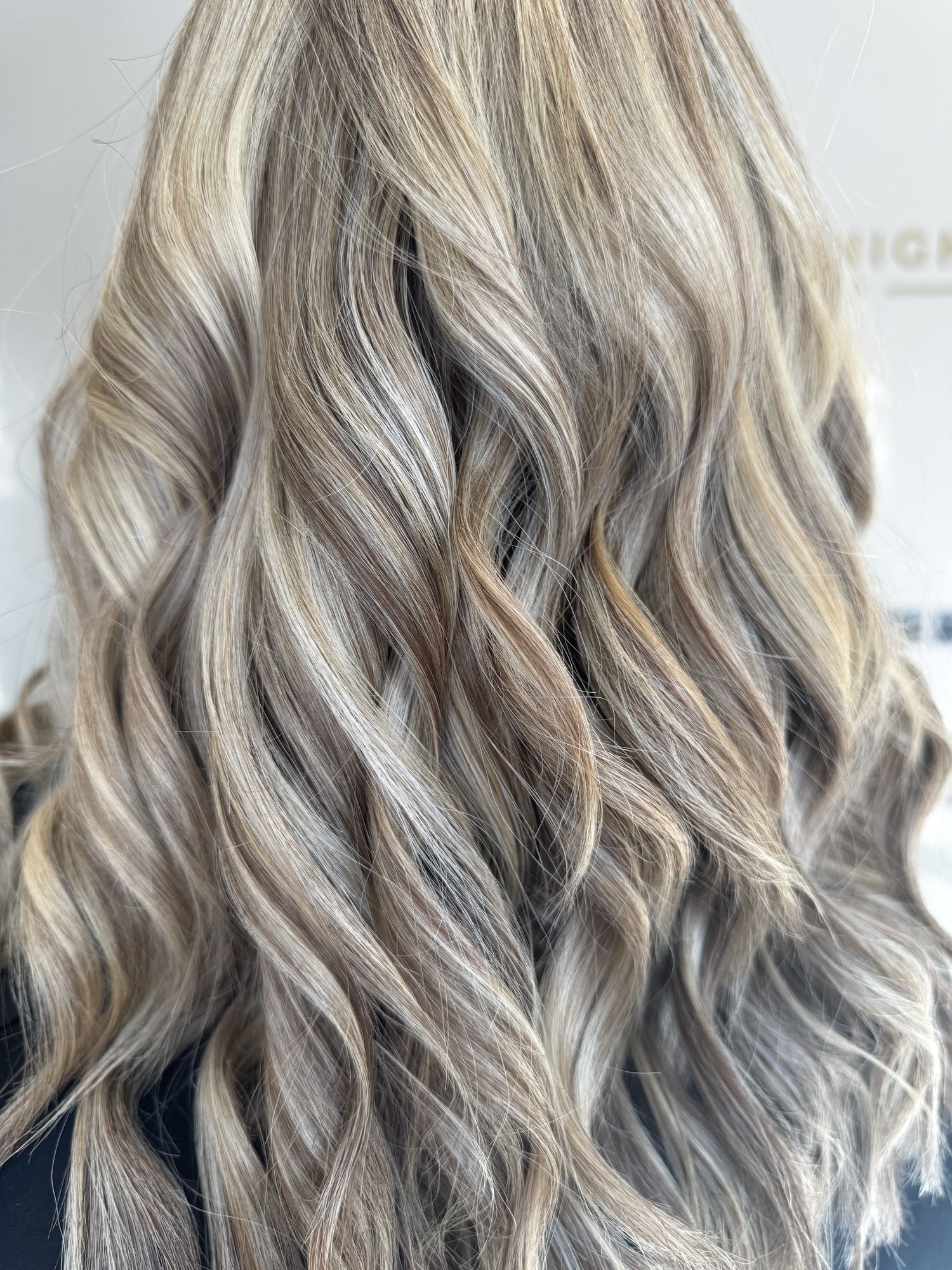 Icy blonde waves styled by Holly Syrett — close-up of soft, glossy curls