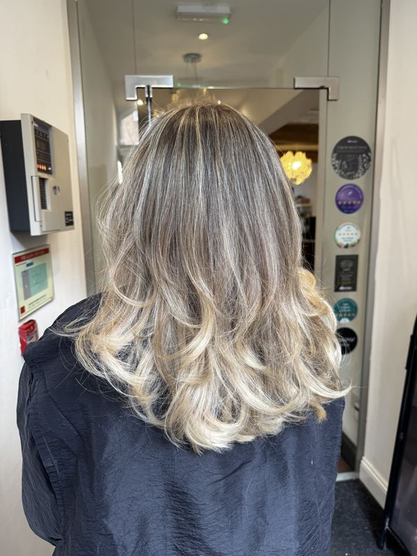 Soft blonde balayage with tumbling curls